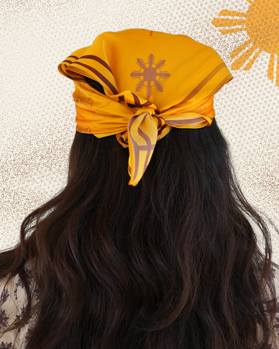 Model wearing a yellow headscarf with a sun design on a textured beige background