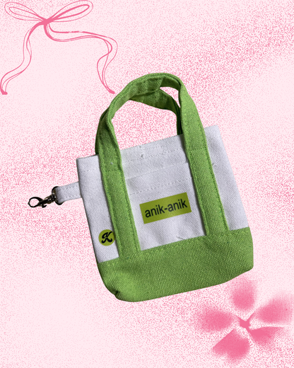 Two-toned green micro tote bag with 'anik-anik' graphic text