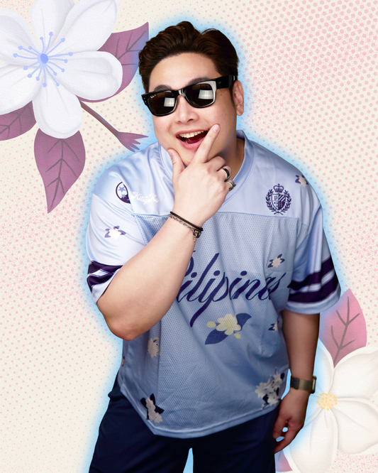 Model wearing blue football jersey with 'pilipinas' in cursive text and sampaguita flower prints all over